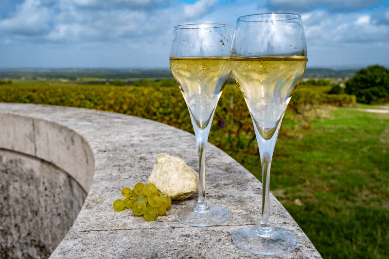Zwei-Glaeser-Blanc-de-Blancs-auf-einer-Mauer